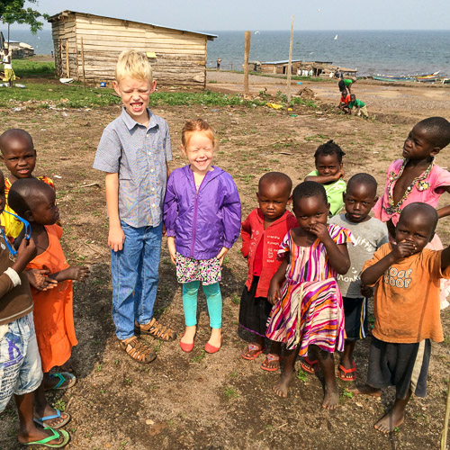 Brent and Virginia Earwicker's children stand among Ugandan children on Kimi Island, Lake Victoria